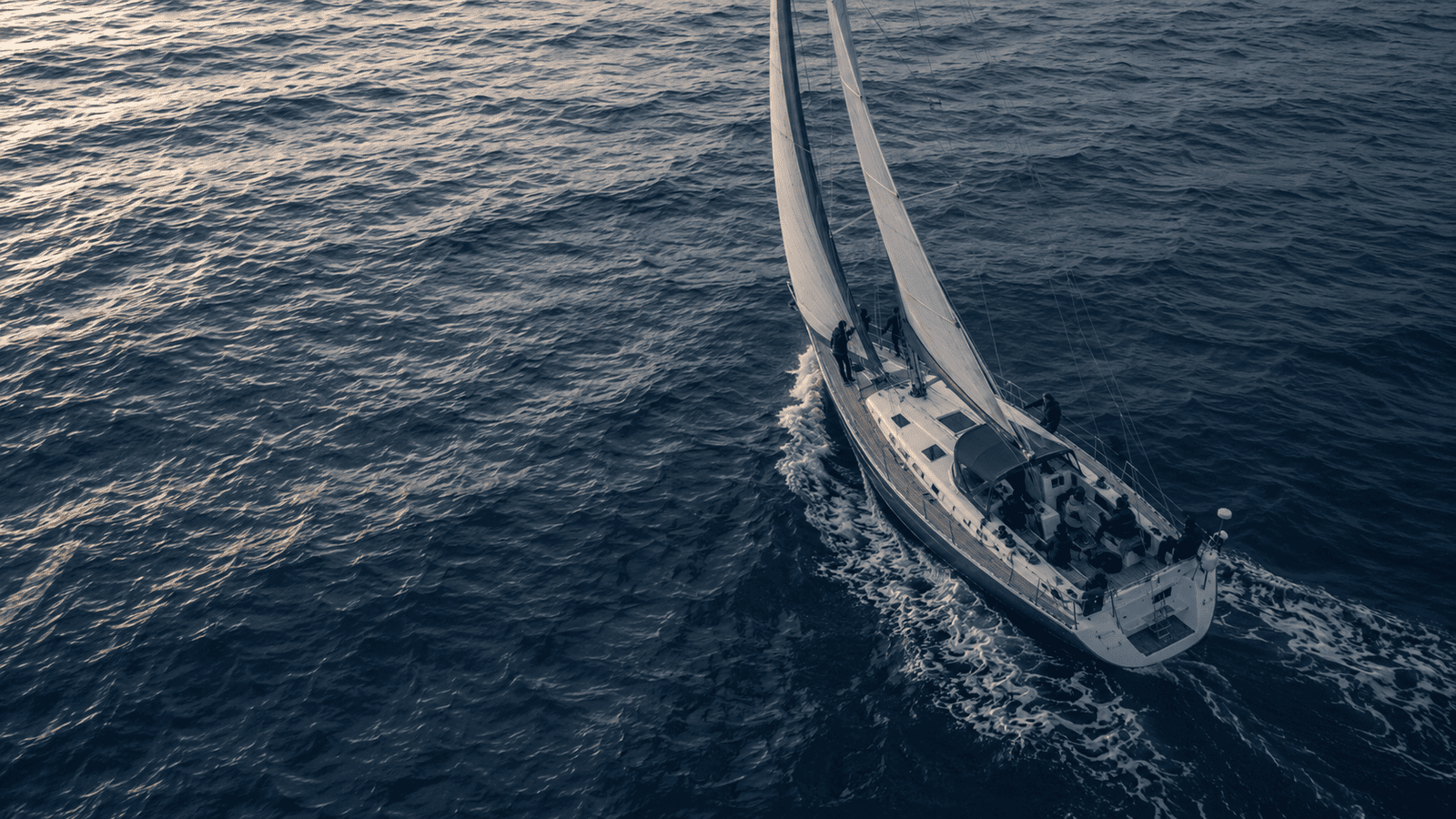 Segelyacht aus der Vogelperspektive segelnd auf offenem Meer
